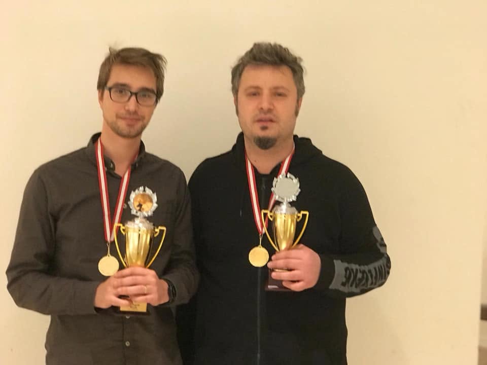 Mircea and a fellow competitor holding trophies and wearing medals
